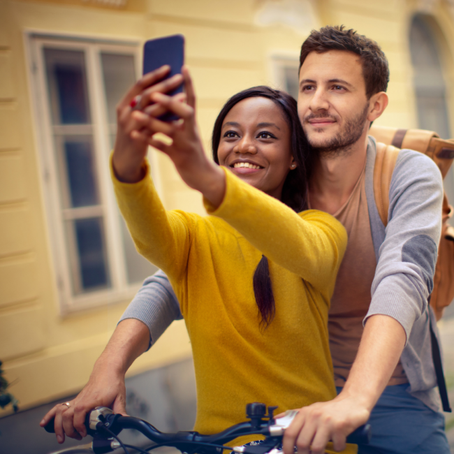man and woman on a bicycle taking a picture