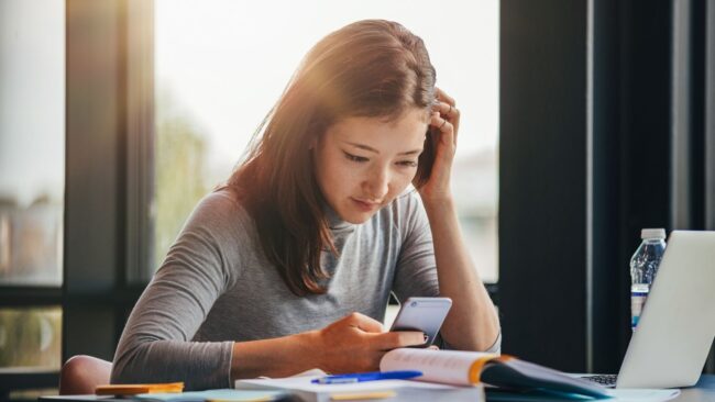 Untitled design (6) woman looking at phone