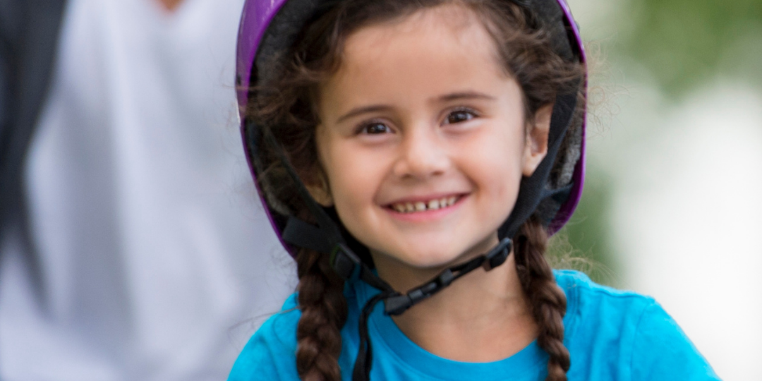 girl on purple bike with helmet