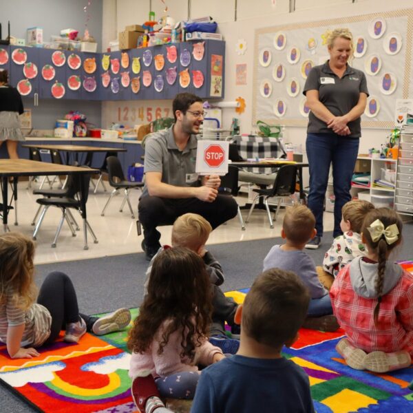A man and a woman are speaking in a classroom.