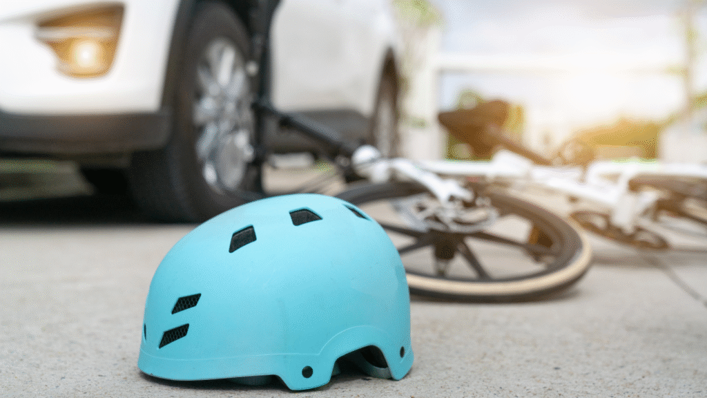 helmet and bicycle on the ground next to a car