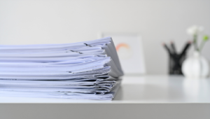 stack of papers on a white desk