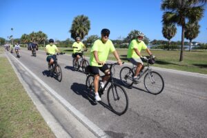 a group of bikers riding down a paved road