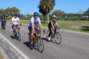 a group of people biking down a paved road