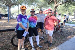 two men and two women standing with bikes