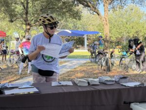 woman at a table looking at brochure in a park