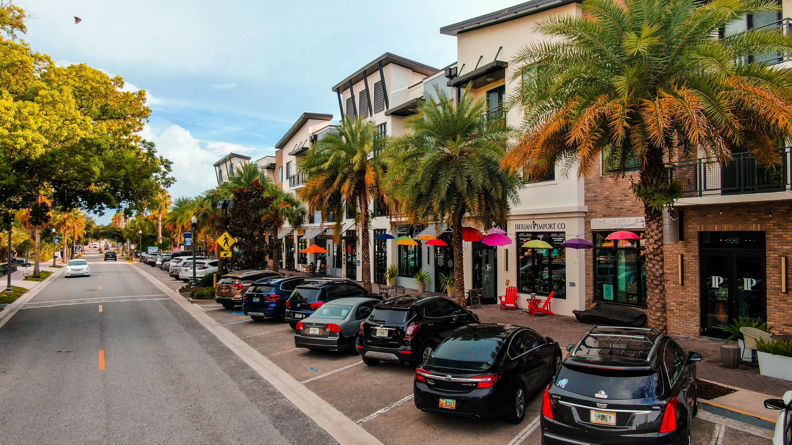 street view of Douglas ave in Dunedin, FL. the street is on the left side and cards parked in front of two-story store fronts on the right side.