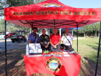 Tarpon Springs Fire Rescue staff standing with a red tent and table